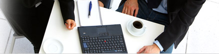 photo slice of people meeting around a table with a laptop